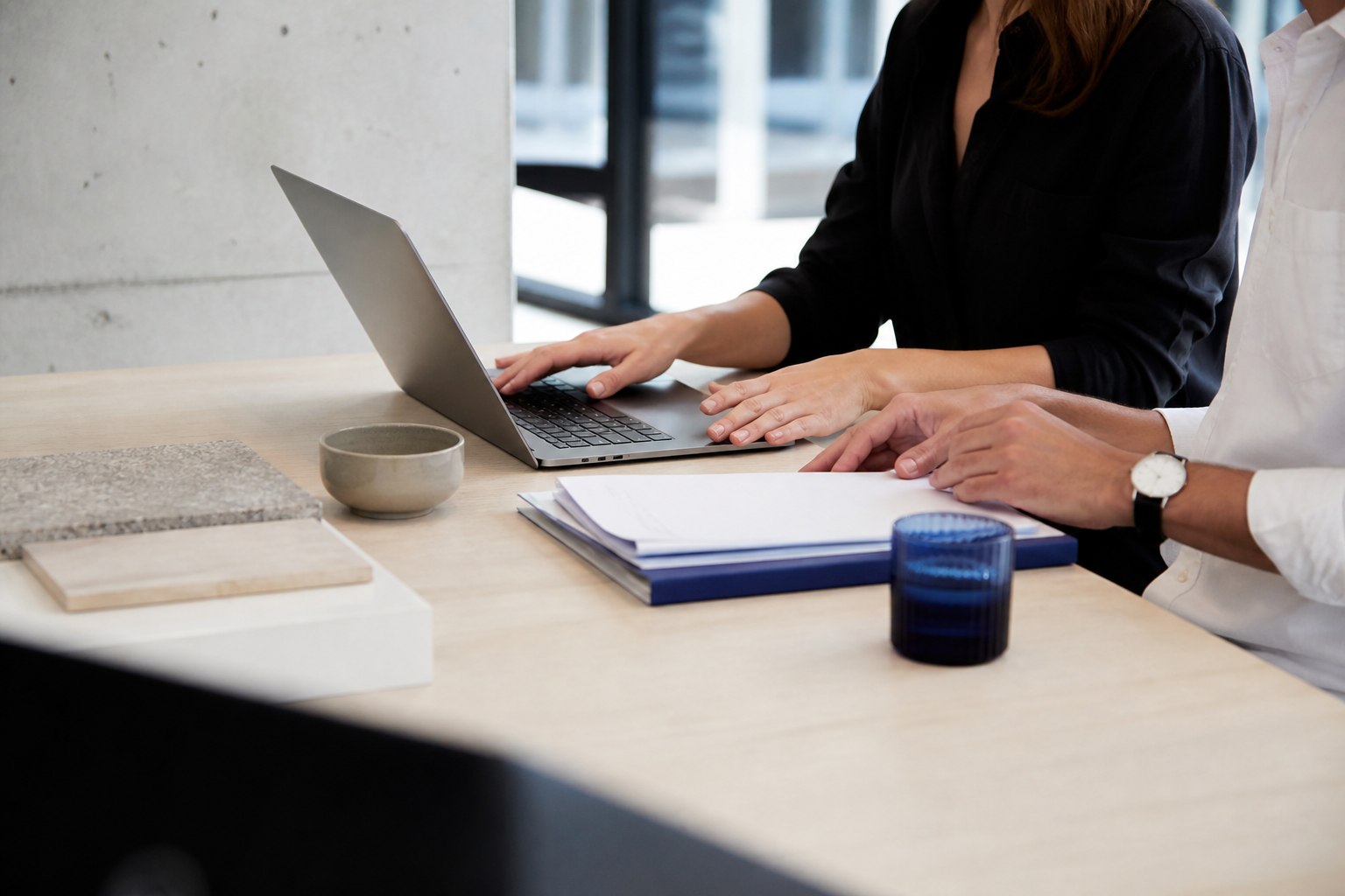 Small-business owner and bookkeeper reviewing an organised financial file together